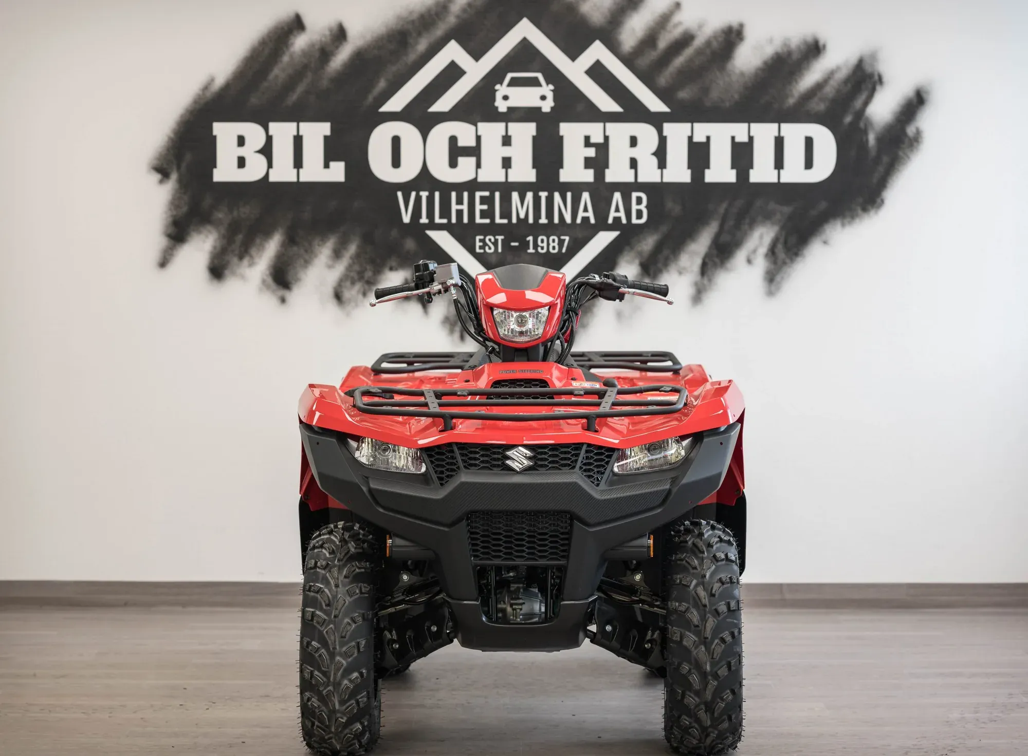 Röd Suzuki-ATV framifrån, framför Bil och Fritids logotypvägg